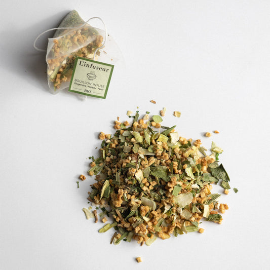 Dried herbs with a tea bag labeled 'L'infuseur' on a light gray background, Organic Leek–Ginger Broth by L'Infuseur – Plant-Based Blend