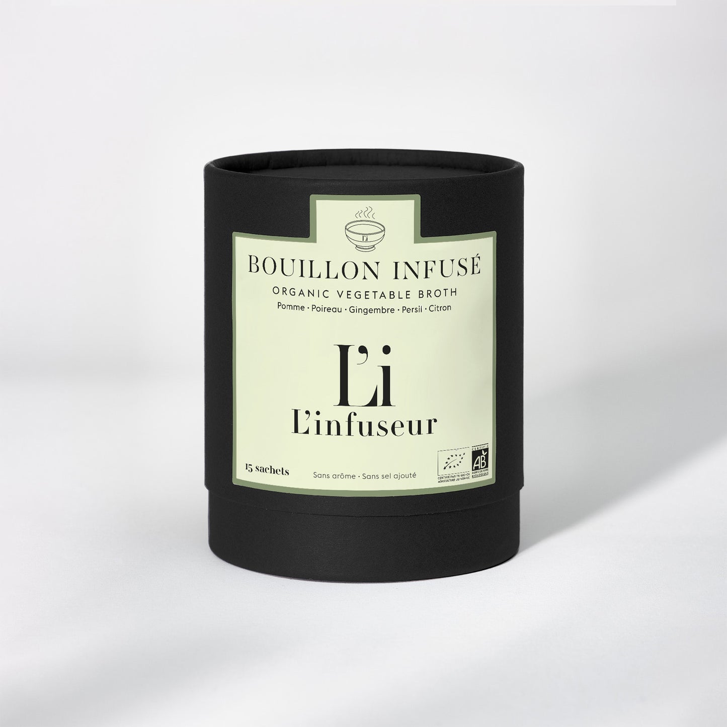 Black container with a label for organic vegetable broth on a white background. Organic Leek–Ginger Broth by L'Infuseur – Plant-Based Blend
