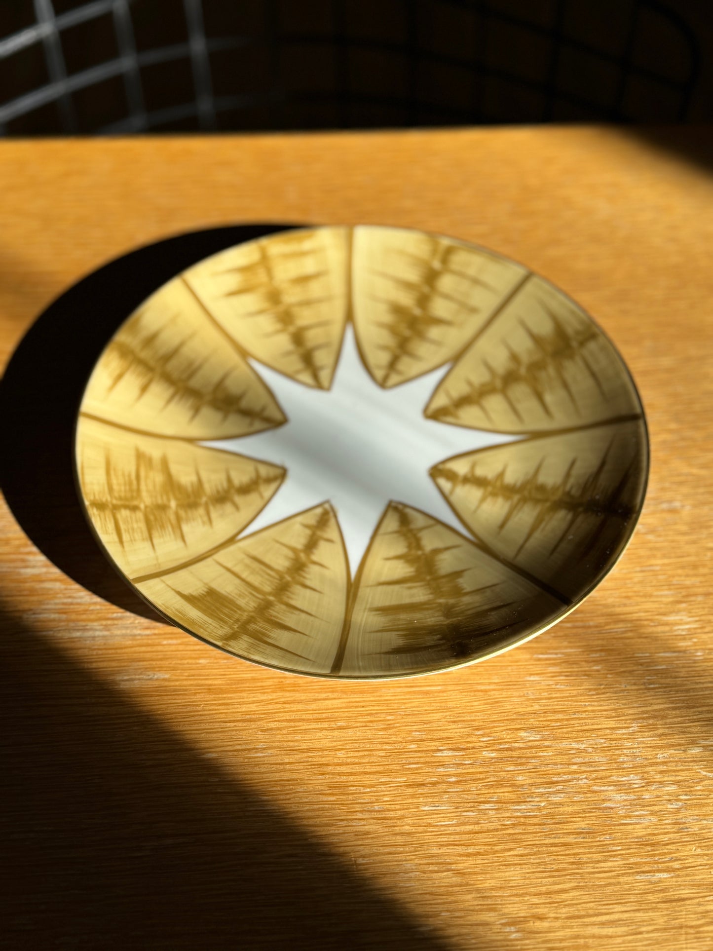 Decorative gold circular plate with star design on a wooden surface, Agave Hand-Painted Dessert Plate – Porcelain – Marie Daâge