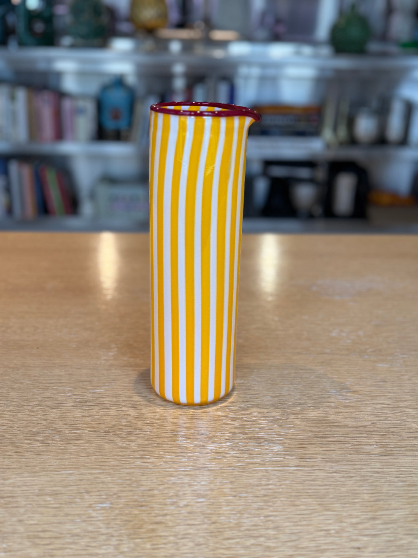 Yellow and white striped vase on a wooden surface with a blurred background, Joyful Stripe Pitcher – Murano Glass by France Thierard – Maison Holder