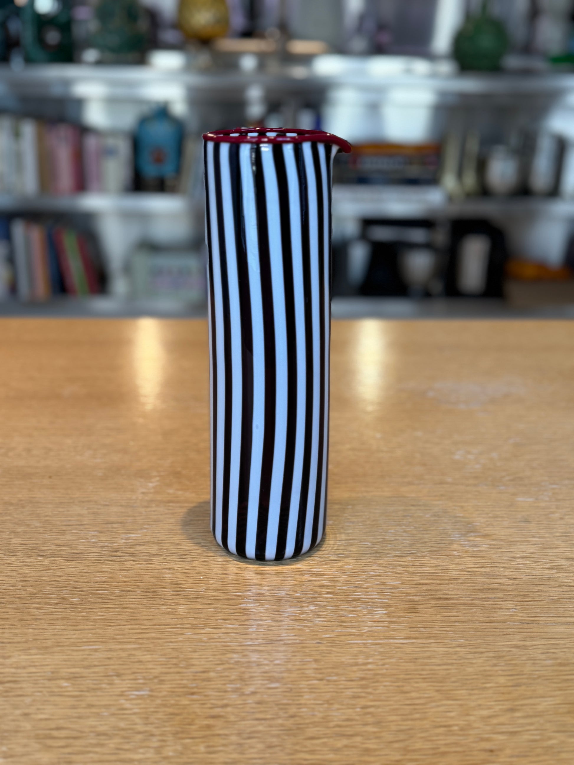 Tall cylindrical container with black and white stripes on a wooden surface, Joyful Stripe Pitcher – Murano Glass by France Thierard – Maison Holder