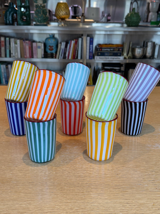 Colorful striped glasses on a wooden floor with a bookshelf in the background, Joyful Stripe Glasses – Murano Cane Glassware – Maison Holder