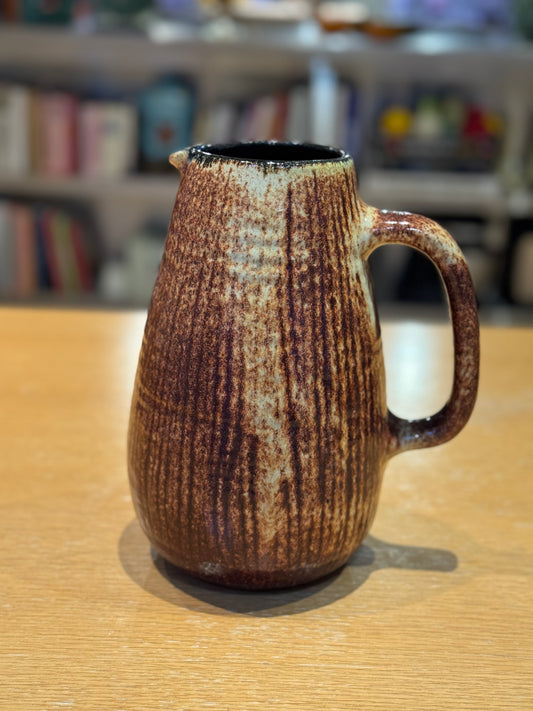 Brown ceramic pitcher on a wooden surface with a blurred bookshelf background, Mid-Century Vintage Vase/Pitcher – French Stoneware – Maison Holder