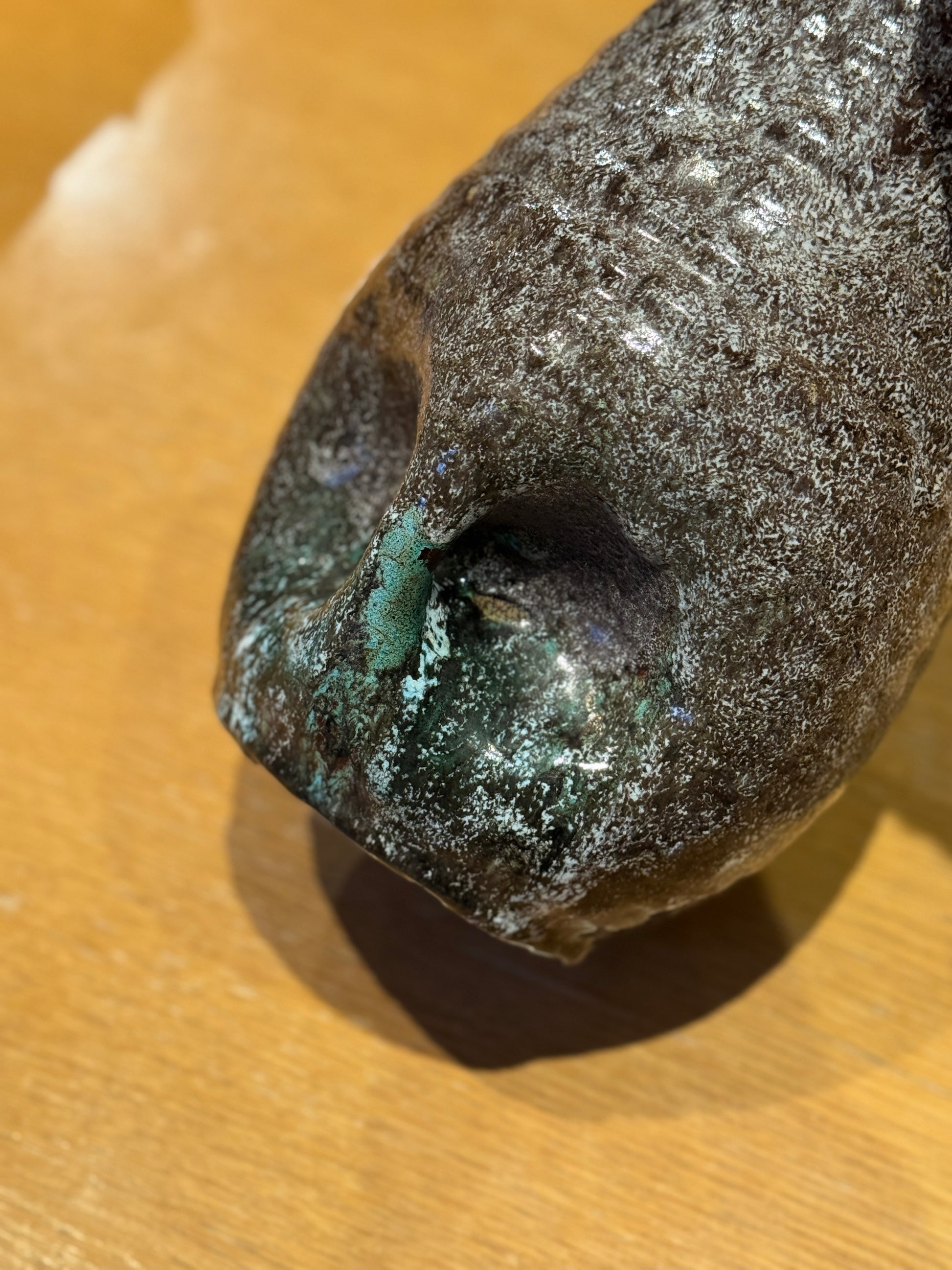 Vintage Vase - Accolay 1960s, Speckled brown and black ceramic vase on a wooden surface with a blurred bookshelf background