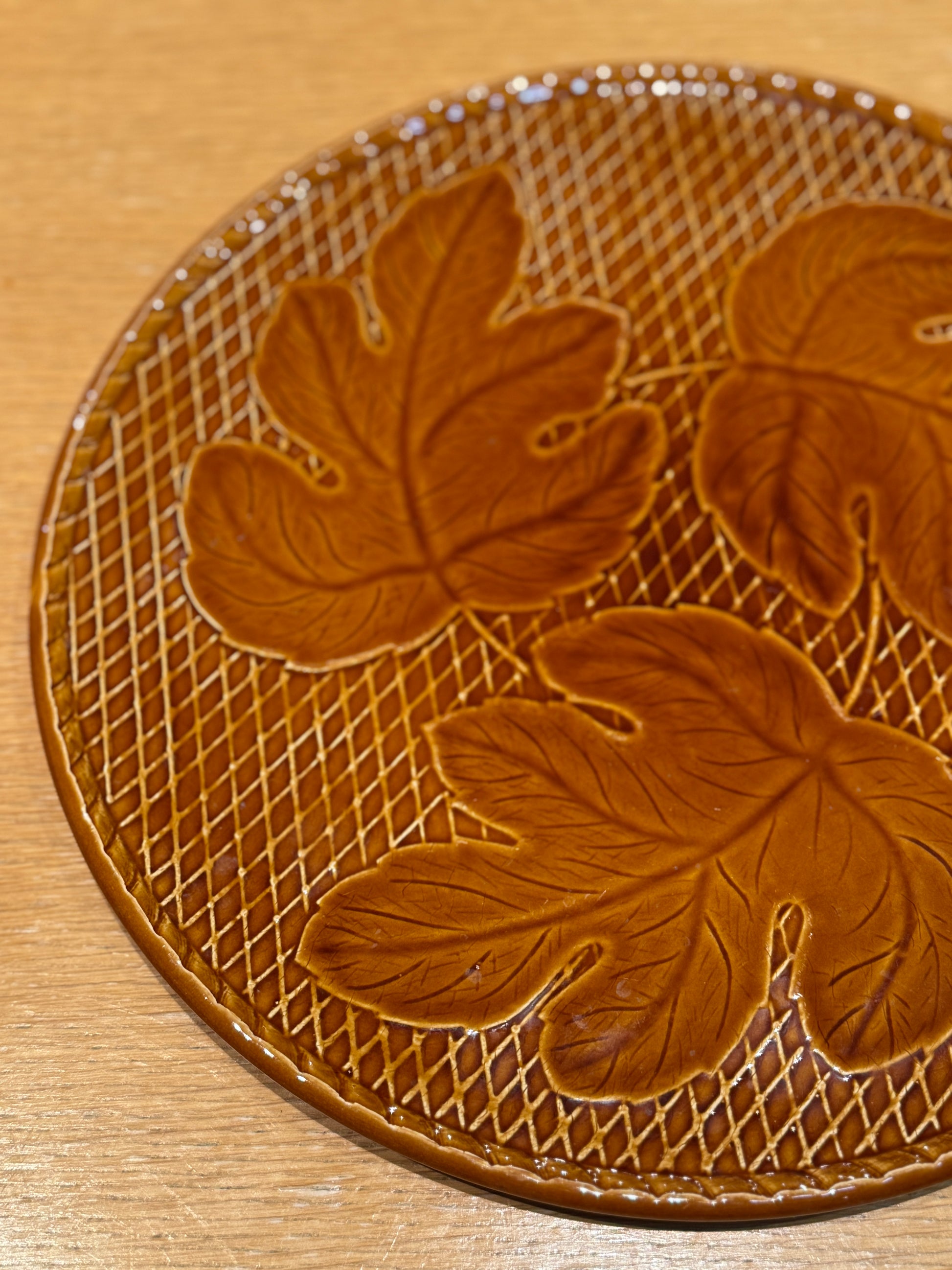 Round brown leather mat with leaf patterns on a wooden surface, vintage Cheese or Dessert Plate