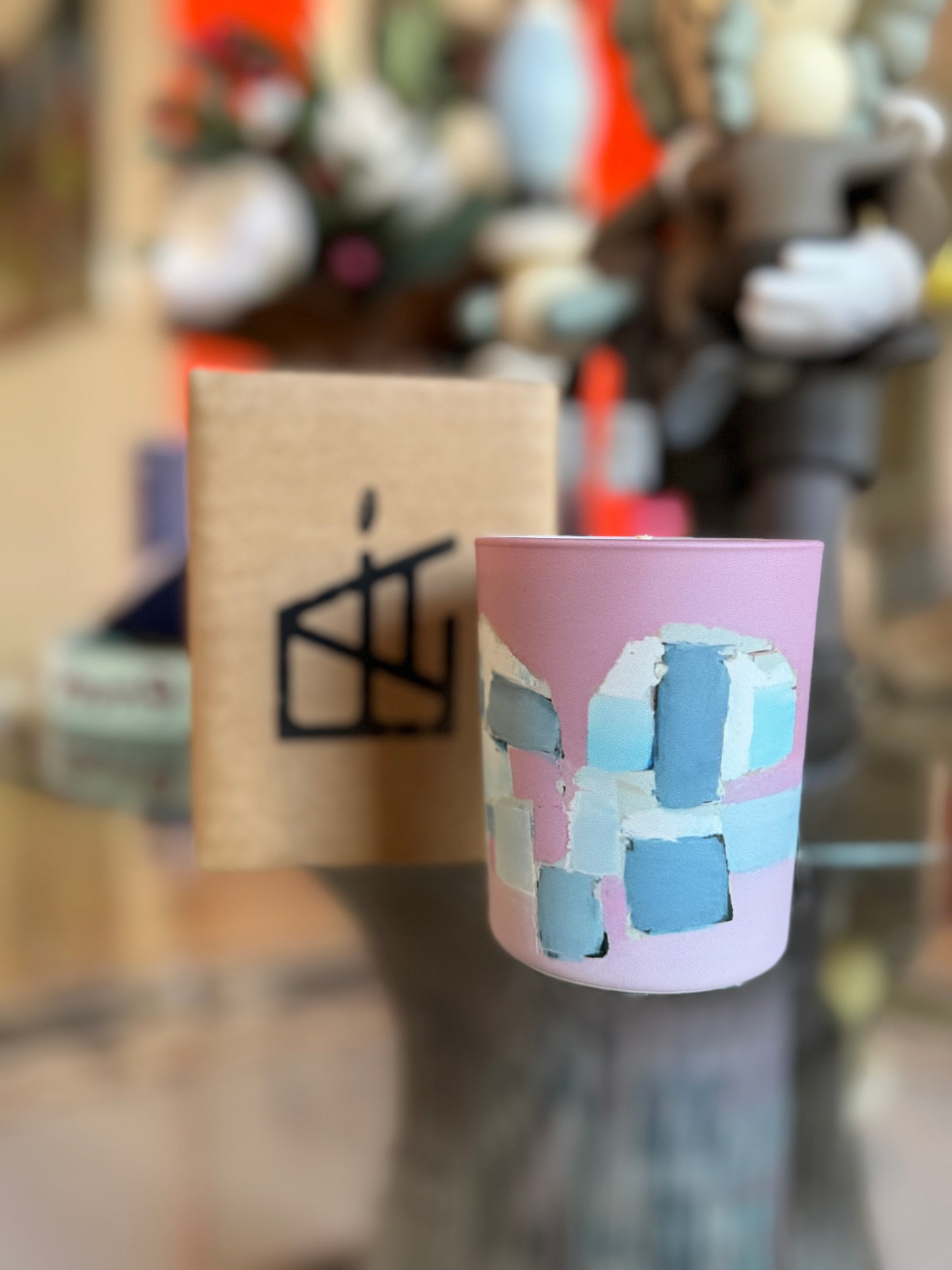 Pink cup with geometric design held in front of a blurred background, Nicolas de Staël Candle – Épreuve d’Artistes – Maison Holder