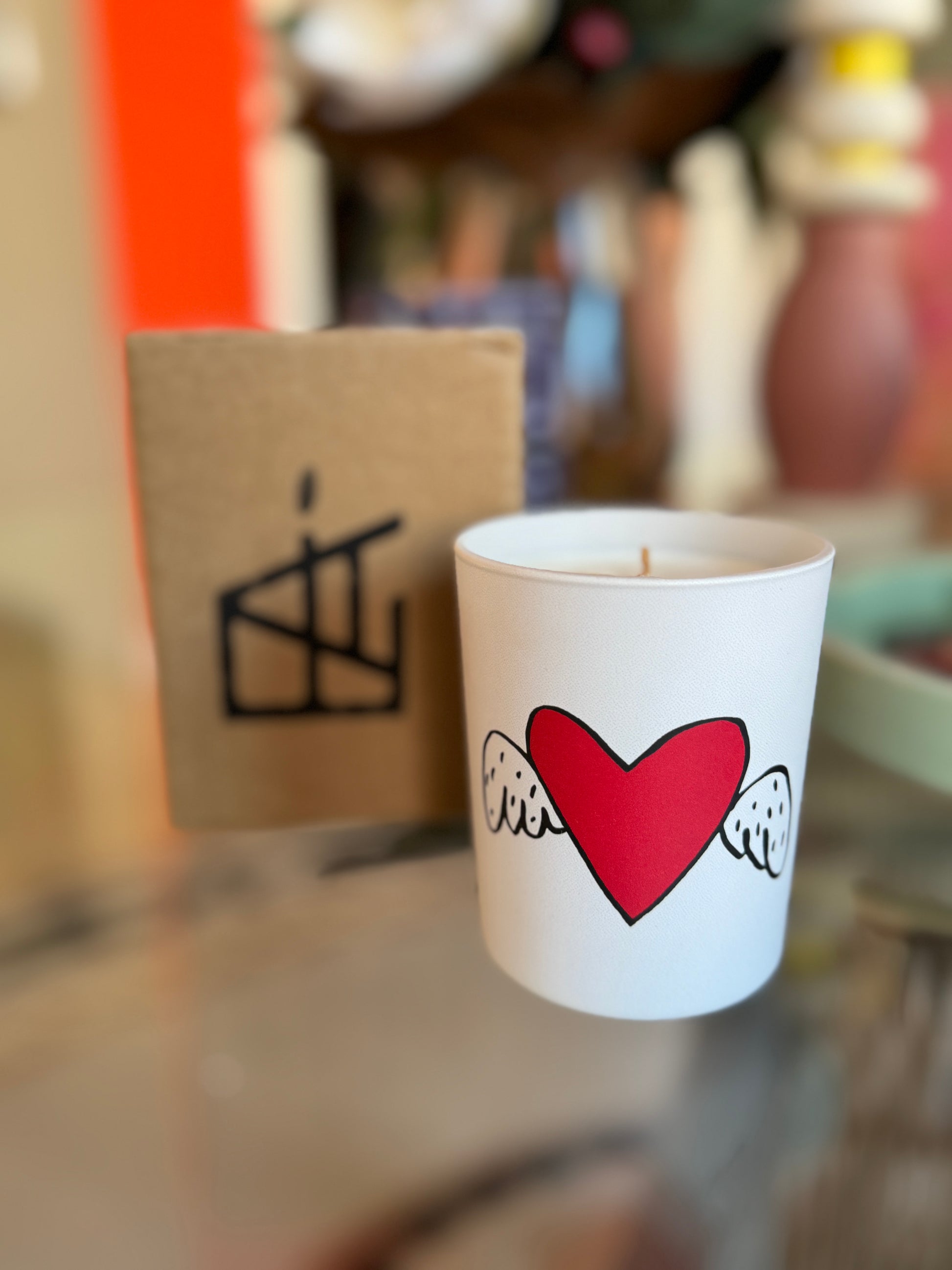 White mug with red heart and white text on a blurred background, Jean-Charles de Castelbajac Art Candle – Épreuve d’Artistes – Maison Holder