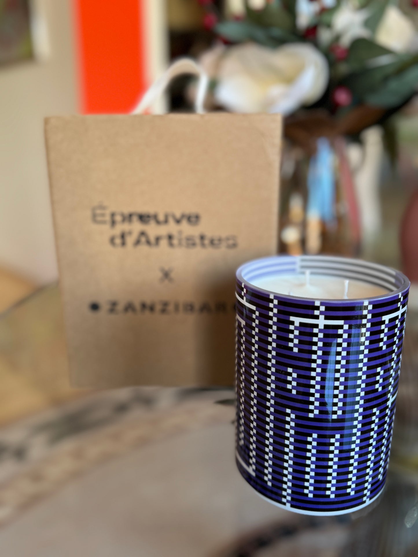 Candle with blue and white pattern in front of a brown box labeled 'Epreuve d'Artistes x ZANZIBAR'. L’Atlas Large Candle – Épreuve d’Artistes – Maison Holder