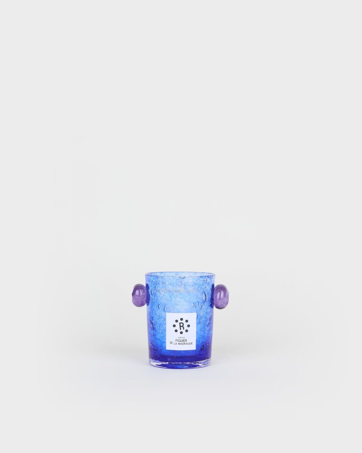 Blue glass candle holder with purple handles on a white background,  Peony Candle Figuier de la Madrague – La Romaine Editions – Maison Holder