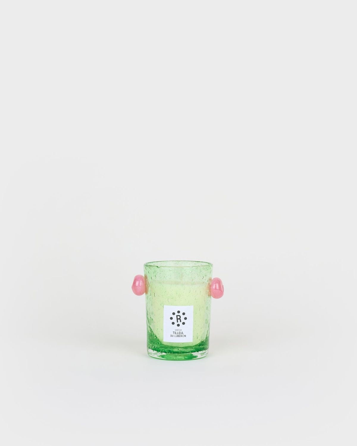 Green glass candle holder with pink handles on a white background, Peony Candle Luberon Lime Blossom – La Romaine Editions – Maison Holder