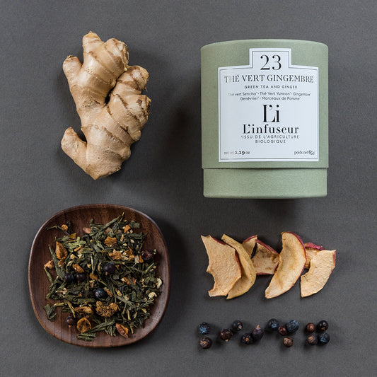 Tea packaging with ginger root, dried leaves, and spices on a gray background, Organic Ginger Green Tea N°23 by L'Infuseur – Antioxidant Blend
