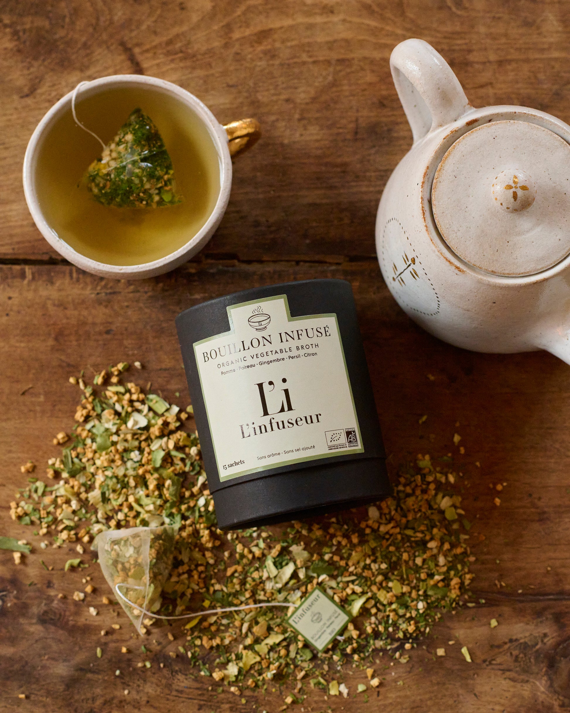 Tea packaging labeled 'Li Infuseur' with a cup of tea and teapot on a wooden surface, Organic Leek–Ginger Broth by L'Infuseur – Plant-Based Blend
