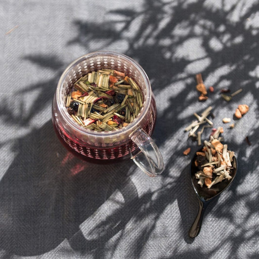 Tea cup with loose tea leaves and a spoonful of tea on a textured surface, Herbal Tea Detox N°6 by L'Infuseur – Hibiscus & Blackcurrant