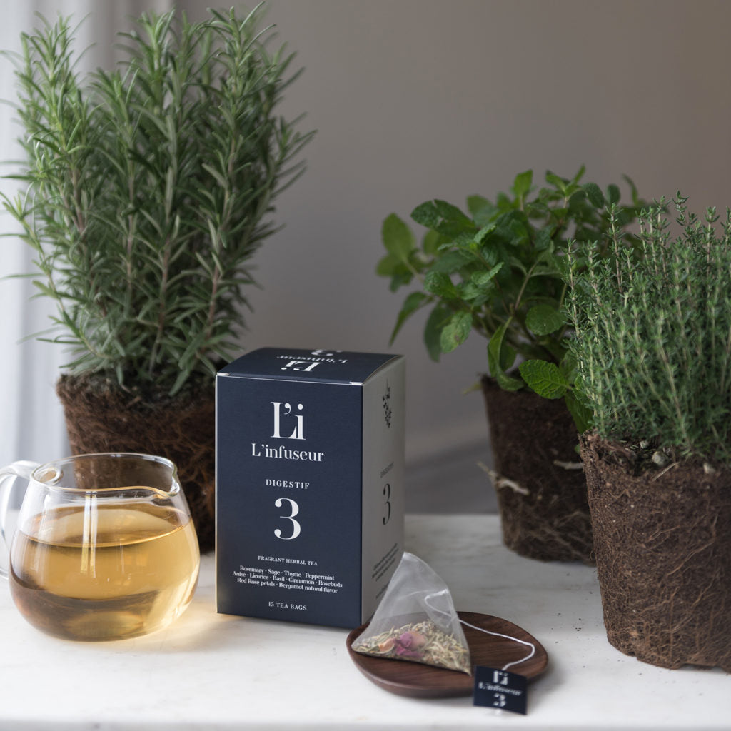 Tea packaging with a cup of tea and herbs on a surface, Herbal Tea Digestif N°3 by L'Infuseur – Thyme & Rosemary