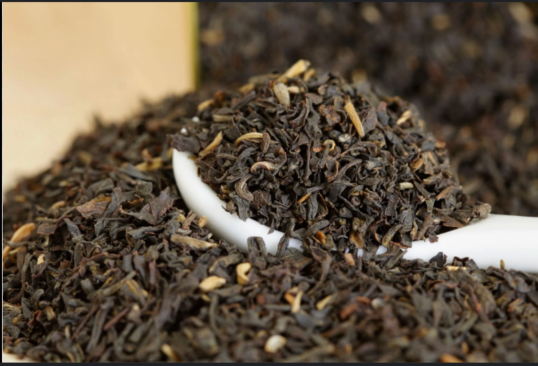 Close-up of dark brown tea leaves with a white object underneath. Organic Breakfast Tea N°18 – Black Tea Blend by L'infuseur