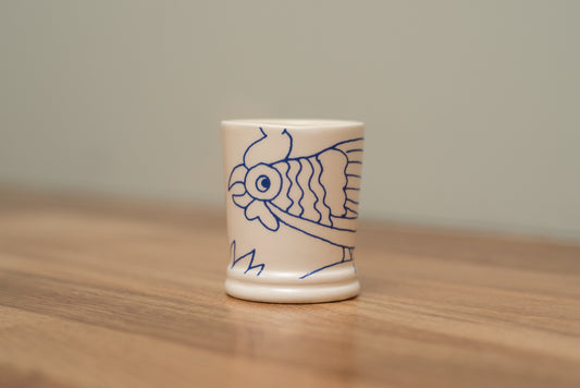 Small ceramic cup with a fish design on a wooden surface, Rouen Decor Espresso Cup – Desvres Earthenware – Maison Holder