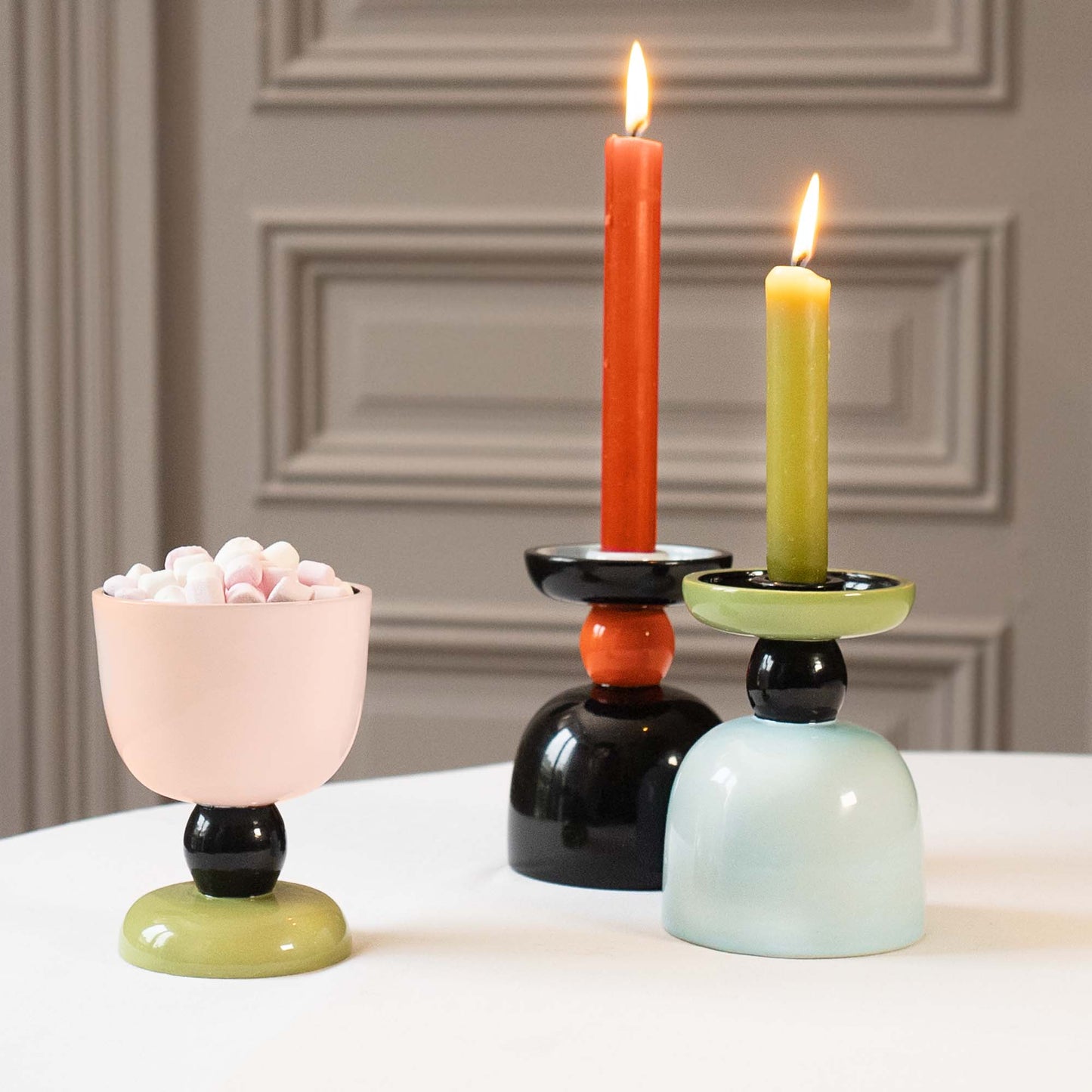 Three colorful candle holders with candles on a neutral background, Calypso Reversible Candle Holder by Olivier Gagnère – Maison Holder