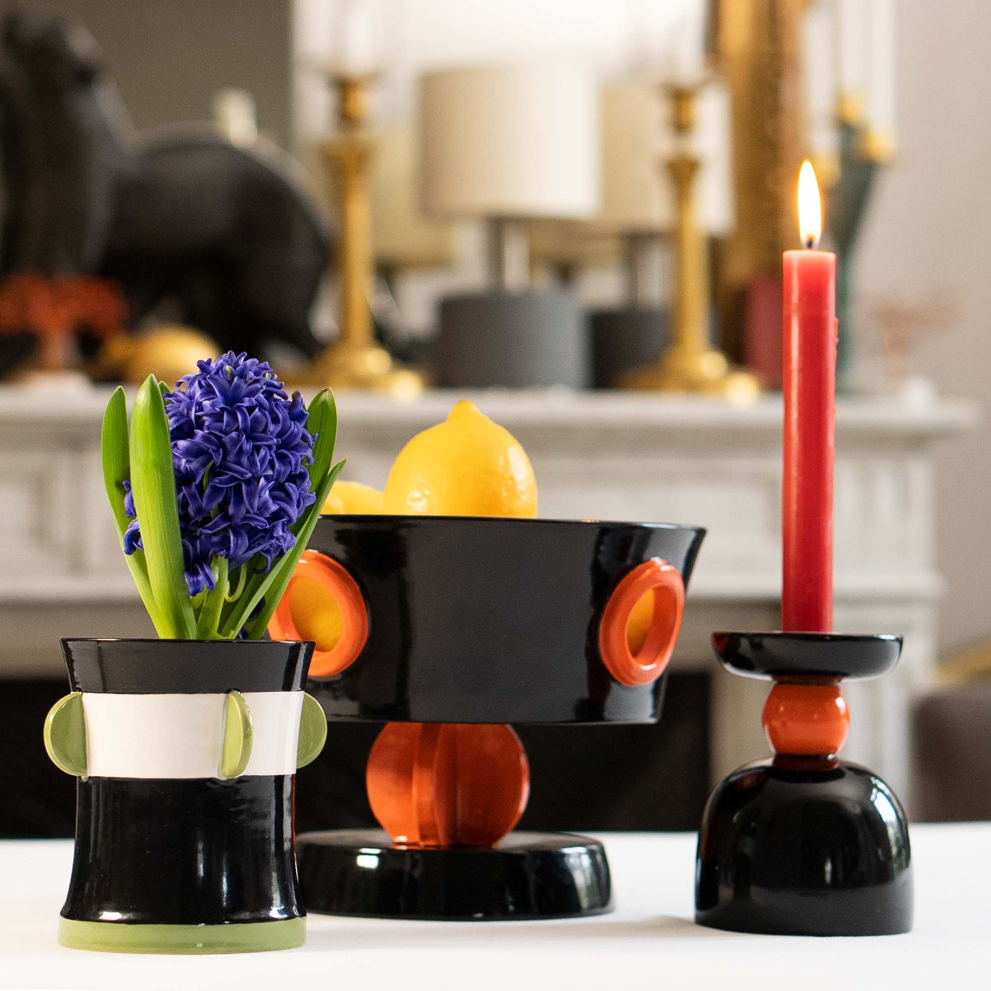 Decorative black and orange candle holder with a red candle and purple flower in a vase., Calypso Black Table Vase by Olivier Gagnère – Ceramic Art – Maison Holder