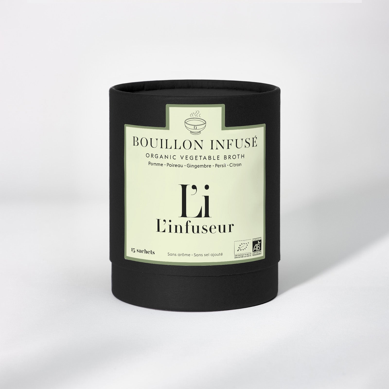 Black container with a label for organic vegetable broth on a white background. Organic Leek–Ginger Broth by L'Infuseur – Plant-Based Blend