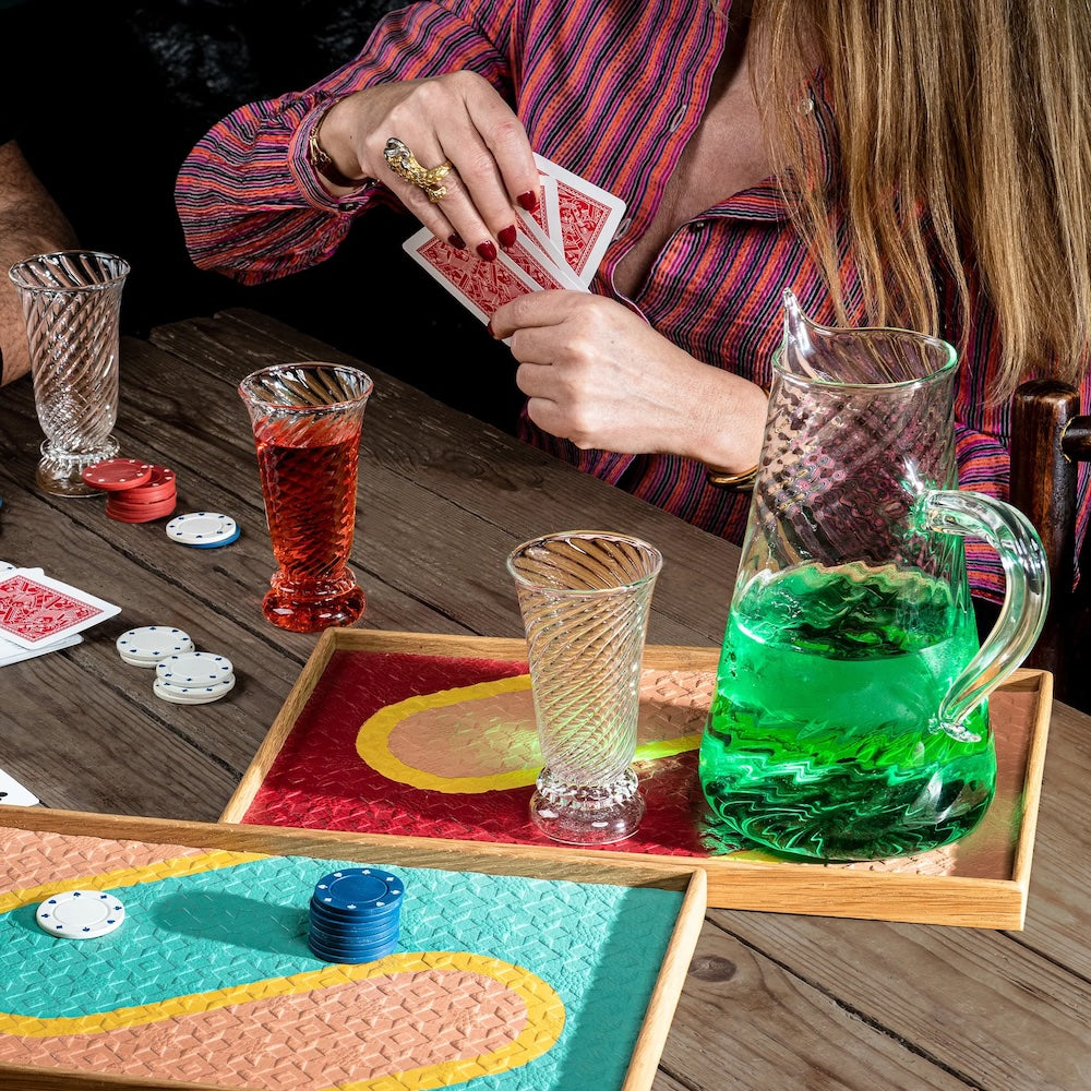 Two people playing cards at a table with drinks and a green pitcher. Nabucho Water Carafe – Elegant Mouth-Blown Glass – Maison Holder