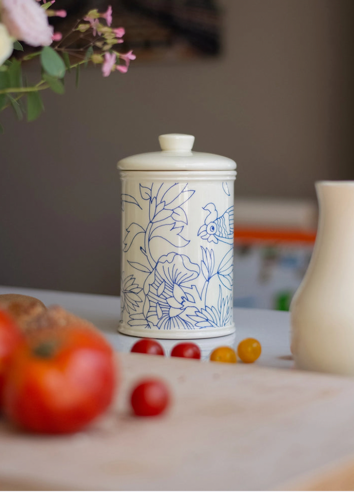 Ceramic jar with floral design on a table with tomatoes and flowers. Rouen Decor Storage Canister – Desvres Earthenware – Maison Holder