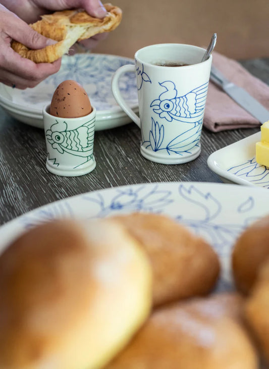 Breakfast scene with croissants, an egg in a fish-shaped cup, and a mug with a fish design on a wooden table., Handcrafted Coffee Cup – Rouen Decor – Des Reves