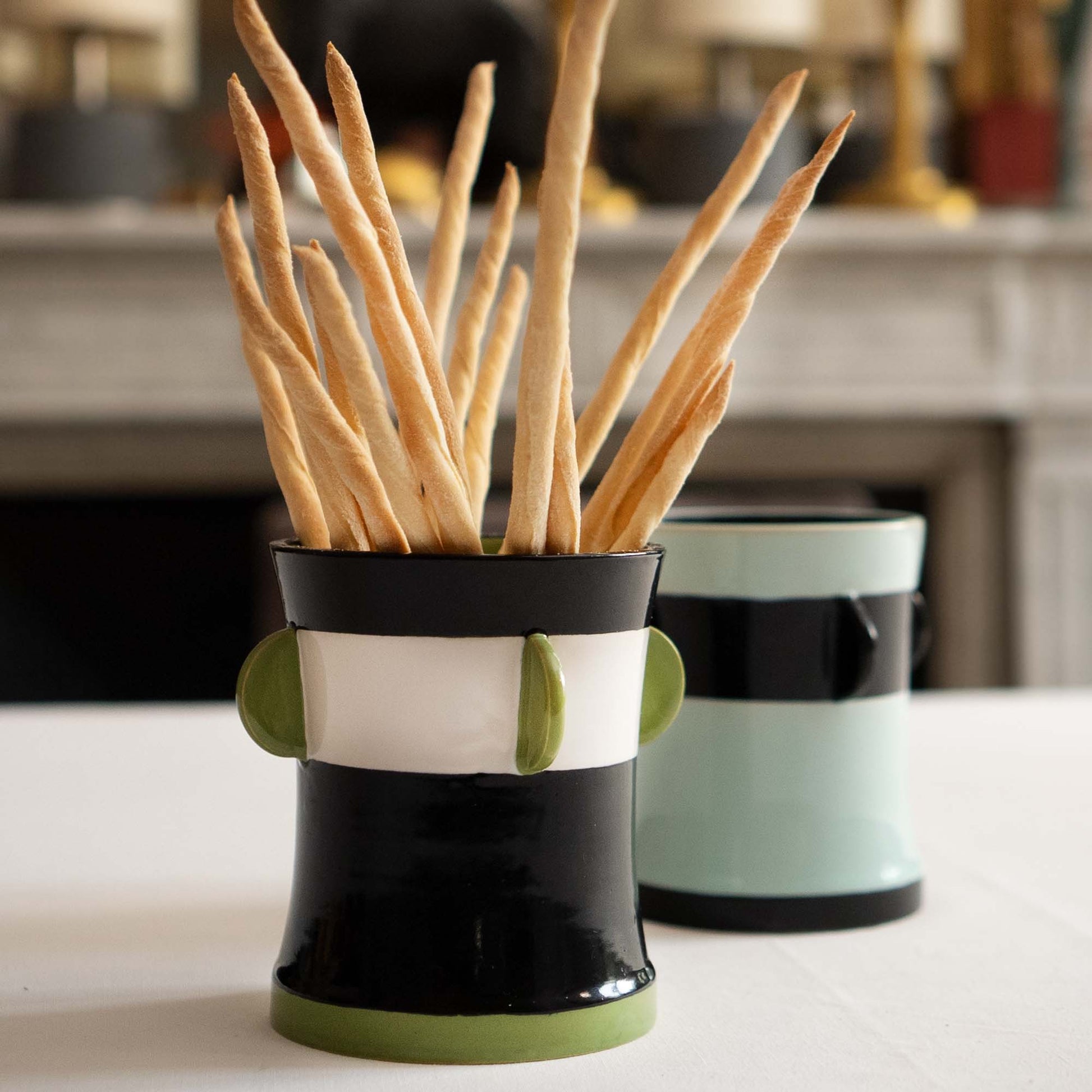 Two ceramic containers with breadsticks on a kitchen counter, Calypso Black Table Vase by Olivier Gagnère – Ceramic Art – Maison Holder