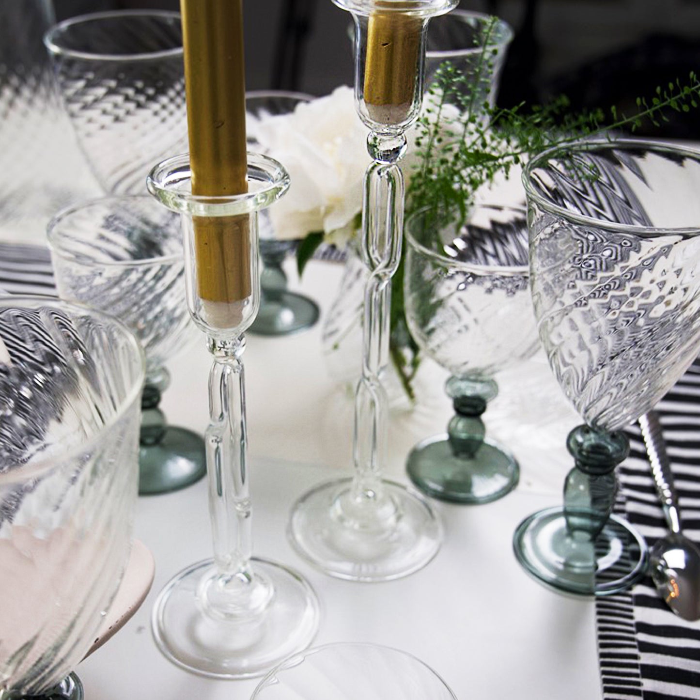 Decorative table setting with glass candlesticks, goblets, and flowers. Infinity Large Candle Holder – Sculptural Glass Art – Maison Holder